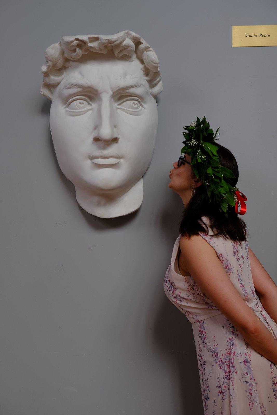 Tiana in a laurel wreath beside a plaster cast of Michelangelo's David
