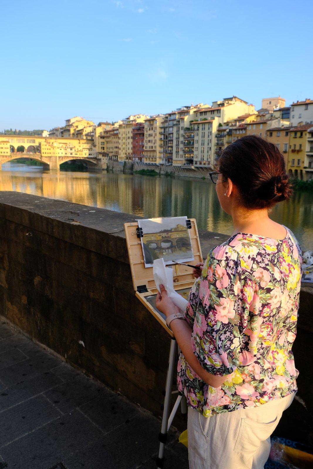 Tiana painting en plein air beside the Arno with the Ponte Vecchio behind
