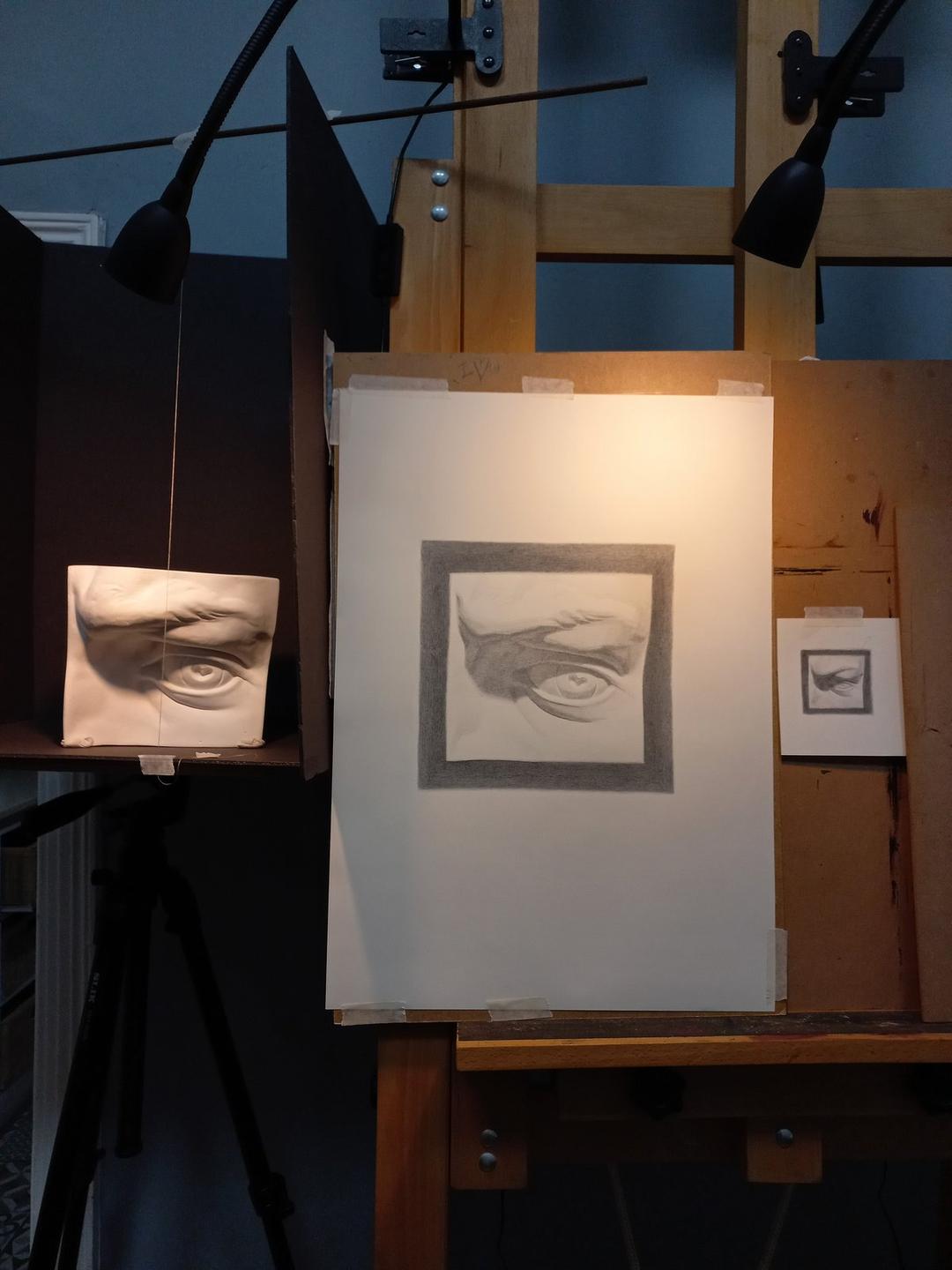 A cast drawing of a sculpted eye beside the plaster cast
