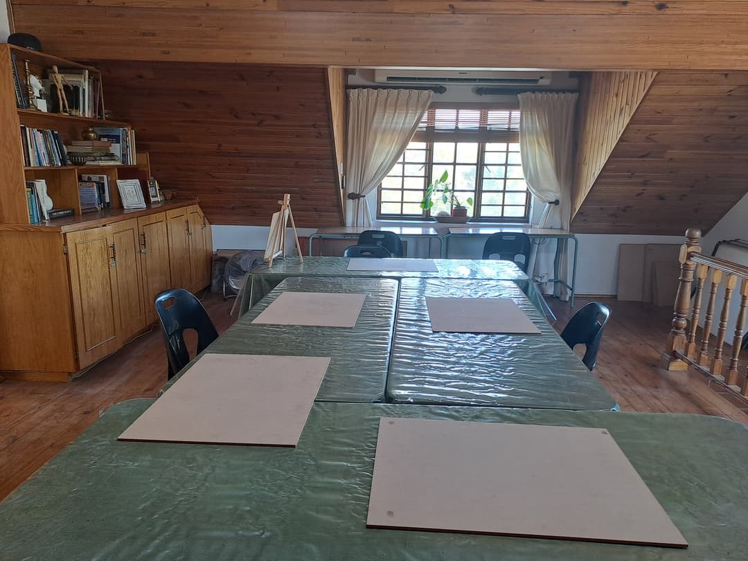The studio classroom set up for a class, with drawing boards on the tables