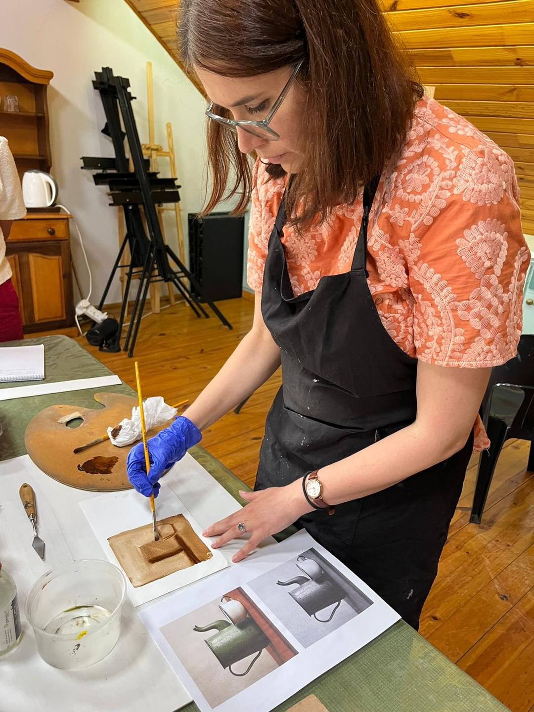A student working on an oil painting during class